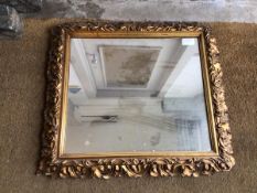 An Edwardian composition wall mirror, the rectangular glass within a foliate gilt frame (63cm x