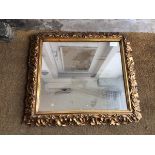 An Edwardian composition wall mirror, the rectangular glass within a foliate gilt frame (63cm x