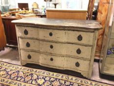 A distressed Continental commode of large proportions, the undulating top with rounded edge above