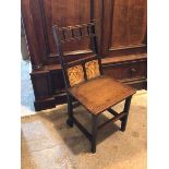 An Edwardian Arts & Crafts style oak side chair with banister top rail and two ceramic plaques,