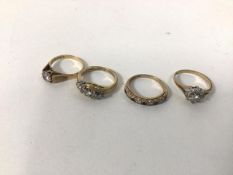 A group of four rings, including a 9ct solitaire CZ set ring (K), a 9ct gold CZ cluster ring, a