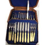 A set of twelve Edwardian knives and forks, with ivory handles and foliate decoration, within an