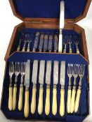 A set of twelve Edwardian knives and forks, with ivory handles and foliate decoration, within an