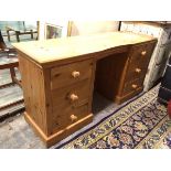 A modern pine dressing table, the rectangular top with moulded edge and shaped front, on two