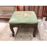 A 1930s/40s footstool with tapestry floral top on moulded apron and supports (29cm x 36cm x 34cm)