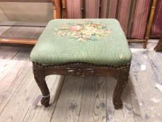 A 1930s/40s footstool with tapestry floral top on moulded apron and supports (29cm x 36cm x 34cm)