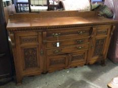 An Edwardian oak sideboard, with ledge back, the top above an egg and dart frieze, fitted an