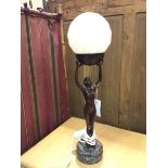 An Art Deco style table lamp with a cold cast bronze figure of a Female Nude holding a spiral opaque