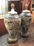 A pair of modern Chinese table lamps, of baluster form with blue and white decoration, on wooden