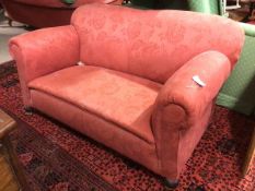 A 1920s/30s sofa, with hump back above scroll arms, on turned front supports terminating in