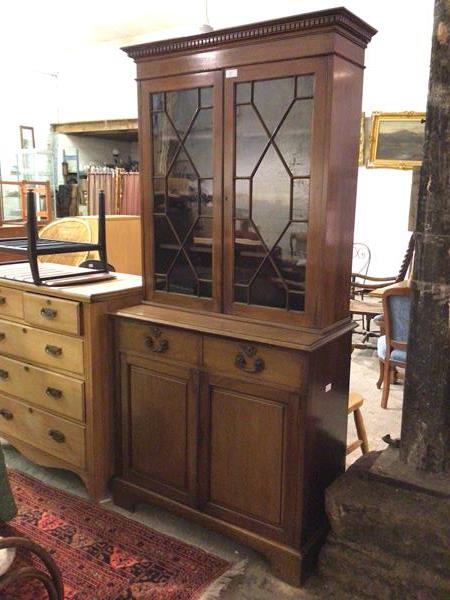 A late 19thc/early 20thc Georgian style bookcase, the moulded top with dentil frieze above two