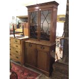 A late 19thc/early 20thc Georgian style bookcase, the moulded top with dentil frieze above two