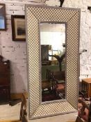 A decorative wall or standing mirror, the rectangular glass within an inner moulded frame, with