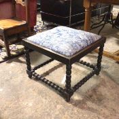 A 1920s footstool with drop in floral upholstered seat, on bobbin supports and stretchers (43cm x