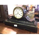 An Edwardian slate mantel clock, the circular dial with roman numerals, on scroll supports and