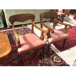 A pair of 19thc armchairs with leather upholstered seats, moulded backs and curved arms, on turned