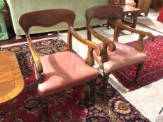 A pair of 19thc armchairs with leather upholstered seats, moulded backs and curved arms, on turned