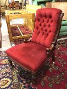 A late Victorian nursing chair with button back and curved sides, on turned front supports with