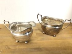 A 1930s Birmingham silver milk jug on bun feet, with matching two handled sugar bowl (combined: