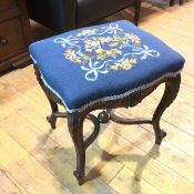 An Edwardian Louis XIV style footstool, with tapestry serpentine top, with carved aprons, on