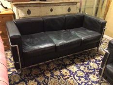 A Le Corbusier style sofa, with black leather back, sides and seats, on chrome tubular frame and