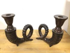 A pair of cast metal candlesticks in the form of a ram's horn (each: 20cm x 19cm x 7cm)