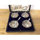 A set of four Edwardian Birmingham silver salts of rococo style with two silver spoons and two