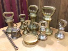 A collection of brass weights, largest 7lb (17cm), a brass bell (11)