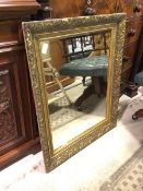 A 19thc mirror, with foliate gilt composition frame (94cm x 76cm)