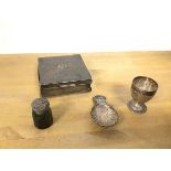 An Edwardian silver cigarette case (3.5cm x 9cm x 9cm), a small silver egg cup and caddy spoon and a