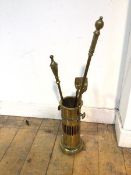 A brass companion set including a cylindrical holder, two pokers and tongs (holder: 26cm x 14cm)