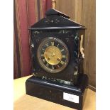 A late 19thc/early 20thc slate mantel clock of traditional style, the dial with roman numerals and