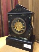 A late 19thc/early 20thc slate mantel clock of traditional style, the dial with roman numerals and