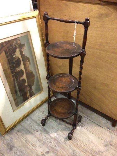 A 1920s oak folding three tier cakestand, on barley twist supports (93cm)