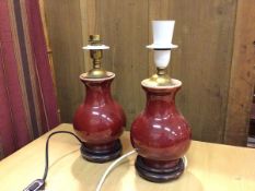 A pair of baluster shaped vase table lamps, possibly converted from vases, with oxblood glaze, on