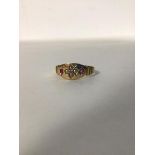 A 15ct gold ring, the oval panel set four seed pearls flanked by two coloured stones (2.1g) (N)