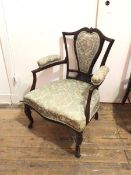 An Edwardian mahogany library chair, with shaped top rail above a floral upholstered splat, with