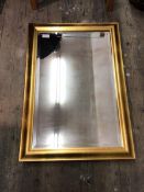 A contemporary wall mirror, the rectangular bevelled glass within a moulded gilt frame (98cm x