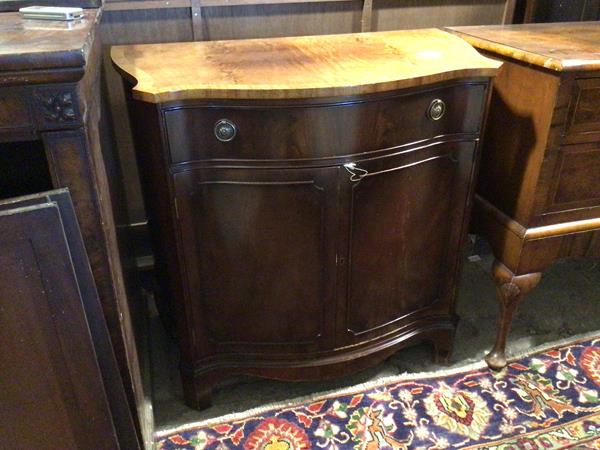 A reproduction Georgian inspired side cabinet, with serpentine top, fitted frieze drawer and two