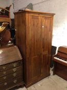 A Morris Furniture & Co. wardrobe, the moulded cornice above two panel doors, with shelved interior,