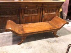 A Regency inspired yew wood bench, with raised scroll ends with floral rosettes, on carved