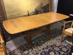 An Ercol extending dining table, with magic leaf, the top with moulded edge, on trestle support (
