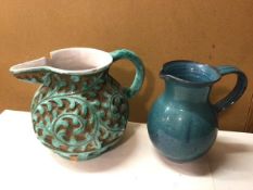 A stoneware water jug, in a turquoise glaze, with handle and foliate pattern in deep relief, chip to