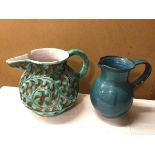 A stoneware water jug, in a turquoise glaze, with handle and foliate pattern in deep relief, chip to