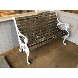 A Victorian style bench with multiple slats for back and seat, and white painted metal ends with