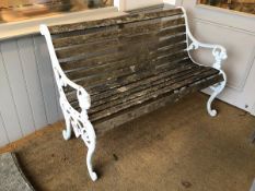 A Victorian style bench with multiple slats for back and seat, and white painted metal ends with