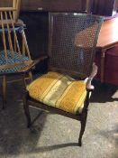 An early 20thc. open armchair with cane back and shaped arms, with seat cushion, on cabriole