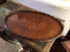 An Edwardian mahogany oval drinks tray, with raised scalloped edge and handles to sides, with