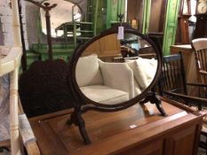 An Edwardian hinged oval mirror, with cast metal bird finial, the mirror on curved supports and