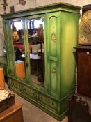 A first half of the 20thc wardrobe, painted green with floral decoration, the moulded cornice